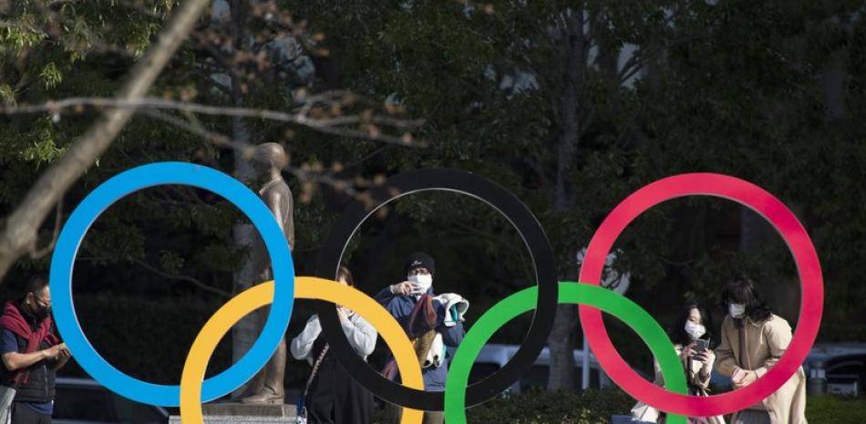Personas tomas fotos de los anillos olímpicos instalados en el Museo Olímpico de Japón, el viernes 19 de marzo de 2021, en Tokio.
