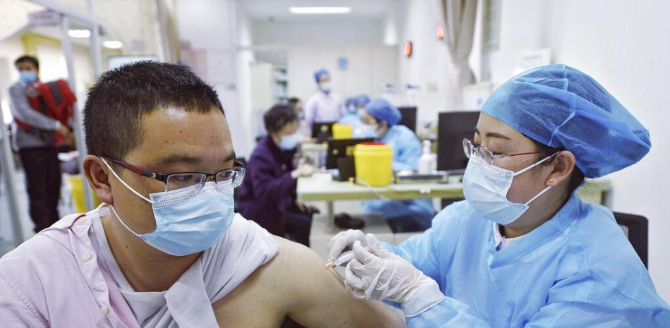 Un hombre con mascarilla para combatir los contagios de coronavirus recibe una dosis de la vacuna de Sinovac contra el COVID-19 en un centro de salud en Hangzhou, en la provincia oriental china de Zhejiang, el lunes 15 de marzo de 2021.

Foto: Chinatopix Via AP