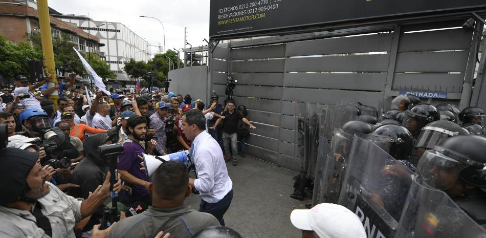 El líder opositor Juan Guaidó pide a sus seguidores no lanzar piedras a la policía que les bloquea el paso en Caracas, Venezuela, el martes 10 de marzo de 2020.

Foto:AP/Matías Delacroix