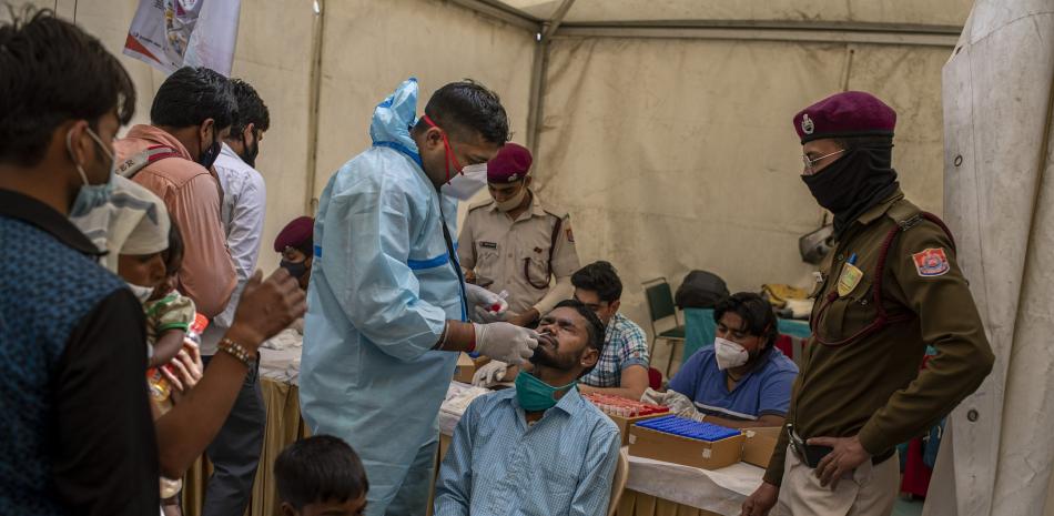 Un enfermero toma una muestra nasal de un pasajero en una prueba de COVID-19 en una terminal de ómnibus en Nueva Delhi, India, miércoles 24 de marzo de 2021.

Foto: AP/Altaf Qadri