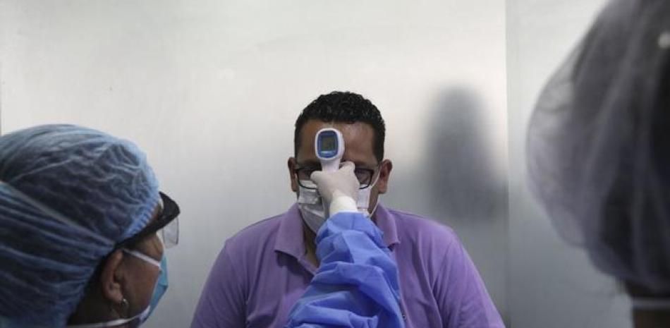 Personal sanitario toma la temperatura a un hombre en un pequeño centro médico en Lima, el miércoles 11 de marzo de 2020, como medida preventiva contra la propagación del nuevo coronavirus.

Foto: AP/Martín Mejía