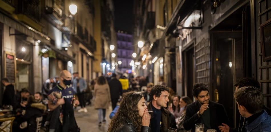 Turistas y residentes en un bar en el centro de Madrid, el 26 de marzo de 2021. Con su política de bares y restaurantes abiertos, Madrid se ha ganado la reputación de oasis de diversión en el desierto de restricciones de Europa. (AP Foto/Bernat Armangue).