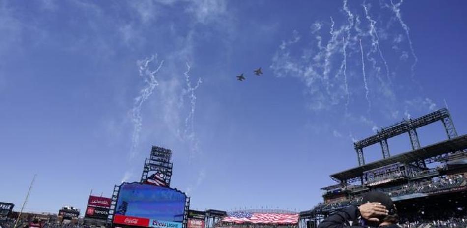 Dos aviones F-16 de la Fuerza Aérea sobrevuelan el Coors Field de Denver, antes del duelo inaugural de la temporada, entre los Rockies de Colorado y los Dodgers de Los Ángeles. (AP Foto/David Zalubowski)