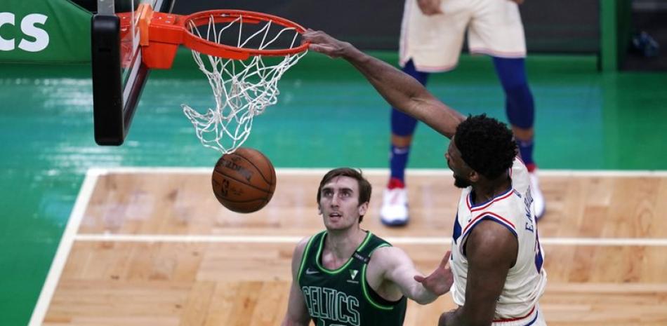 El pivot de los 76ers de Filadelfia Joel Embiid clava el balón mientras lo defiende el pivot de los Celtics de Boston Luke Kornet. (AP Photo/Charles Krupa)