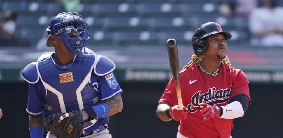 José Ramírez de los Indios de Cleveland observa la bola junto al catcher de los Reales de Kansas City Salvador Pérez en el encuentro de este miércoles.