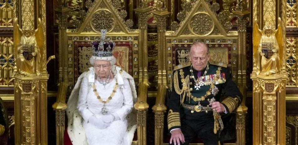 En esta foto de archivo del 18 de mayo de 2016, la reina Isabel II de Gran Bretaña se sienta junto a su esposo, el príncipe Felipe duque de Edimburgo, durante la inauguración del Parlamento en Londres el 18 de mayo de 2016. Foto: Justin Tallis/AFP.