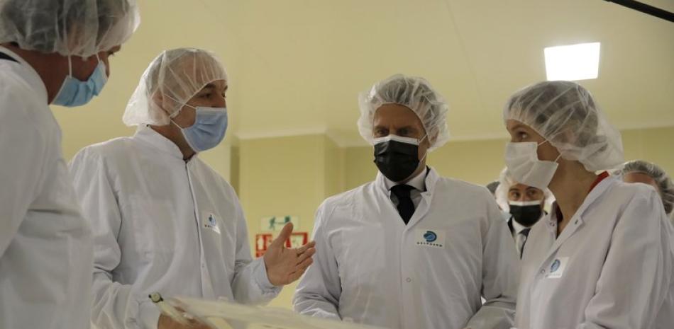 El presidente francés Emmanuel Macron, segundo desde la derecha, visita la planta frarmacéutica Delpharm en Saint-Remy-sur-Avre, al oeste de Paris, el viernes, 9 de abril del 2021. la planta comenzó esta semana a producir la vacuna de Pfizer para el coronavirus. (AP Foto/Christophe Ena, Pool)