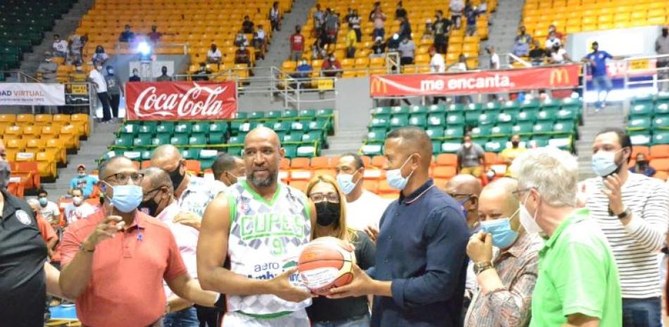Osvaldo López, del Cupes, recibe un balón de recuerdo luego de alcanzar los 500 lances de tres anotados en el baloncesto superior de Santiago.
