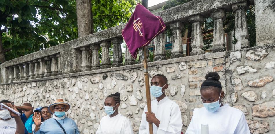 Los clérigos cristianos sostienen una bandera mientras encabezan la procesión del Vía Crucis durante la Semana Santa en Puerto Príncipe, el 2 de abril de 2021.
Reginald LOUISSAINT JR / AFP