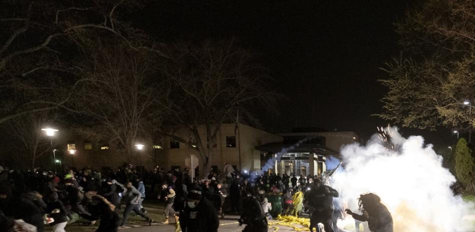 La gente corre mientras la policía intenta dispersar a la multitud en el Departamento de Policía de Brooklyn Center, el domingo 11 de abril de 2021, en Brooklyn Center, Minnesota. (Carlos González / Star Tribune vía AP)
