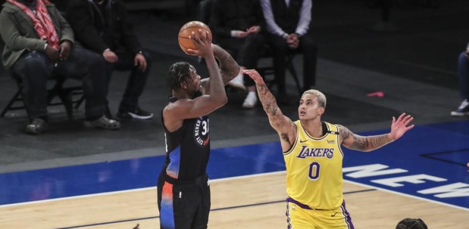 Julius Randke, alero de los Knicks de Nueva York, dispara frente a Kyle Kuzma, de los Lakers de Los Ángeles, en el duelo de este lunes.
