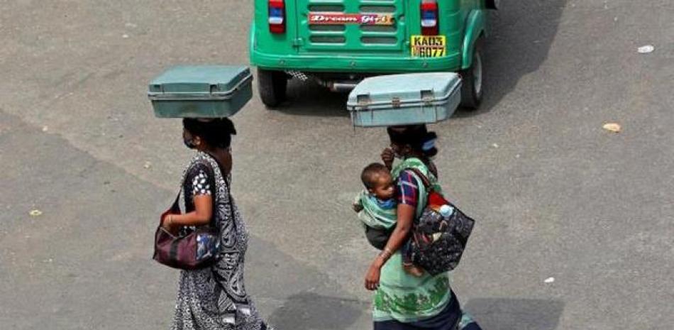 Dos mujeres con mascarillas cruzan una calle en Bangalore. EFE