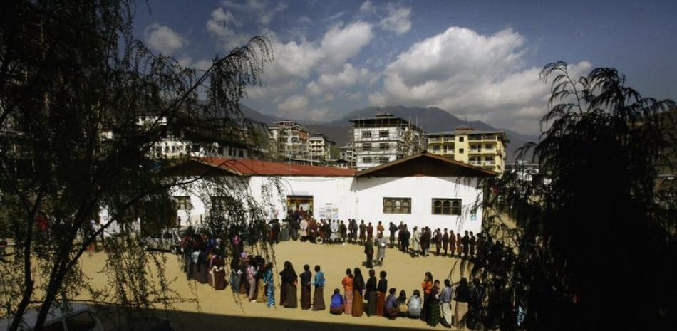 En esta imagen de archivo del 24 de marzo de 2008, butaneses esperando a votar ante un colegio electoral en Timbu, Bután. La campaña de vacunación de Bután contra el COVID-19 fue rápida desde el principio, y casi había terminado tras 16 días. (AP Foto/Manish Swarup, Archivo)