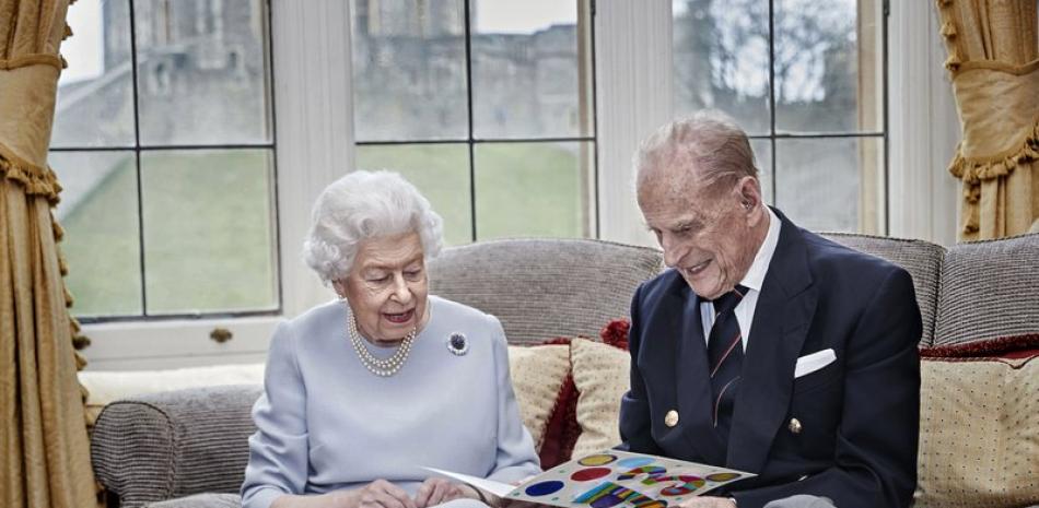 En esta imagen difundida el 19 de noviembre de 2020, la reina Isabel II y el príncipe Felipe leen una tarjeta de aniversario de parte de sus bisnietos, el príncipe Jorge, la princesa Carlota y el príncipe Luis, en el Castillo de Windsor, en Windsor, Inglaterra.

Foto: Chris Jackson/Pool/AP