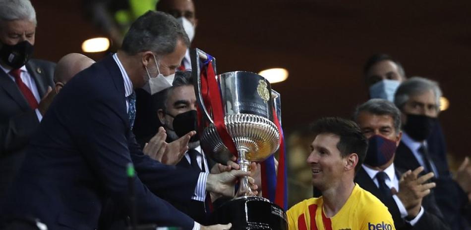 El Rey Felipe de España entrega la Copa del Rey al argentino Lionel Messi, del Barcelona, tras la final ante el Athletic de Bilbao, disputada el sábado 17 de abril de 2021 en Sevilla.