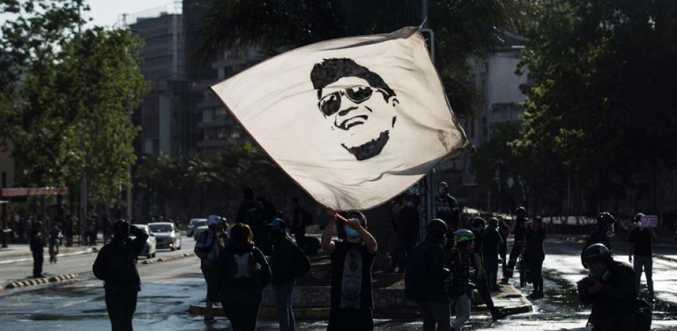 Un manifestante ondea una bandera con la cara de Gustavo Gatica. EFE/ Alberto Valdés/ Archivo