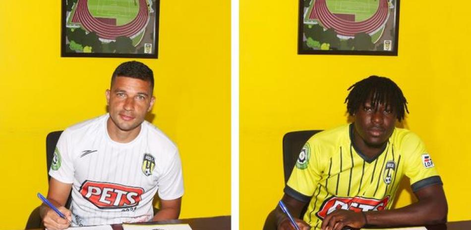 Los delanteros Juan Guillermo Vélez y Lamin Jawneh mientras estampan sus firmas en el contrato con Moca FC.