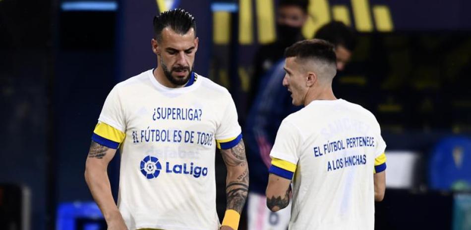 Álvaro Negredo (izquierda) y Salvi Sánchez, del Cádiz, visten camisetas con mensajes de protesta  por la creación de la Superliga.