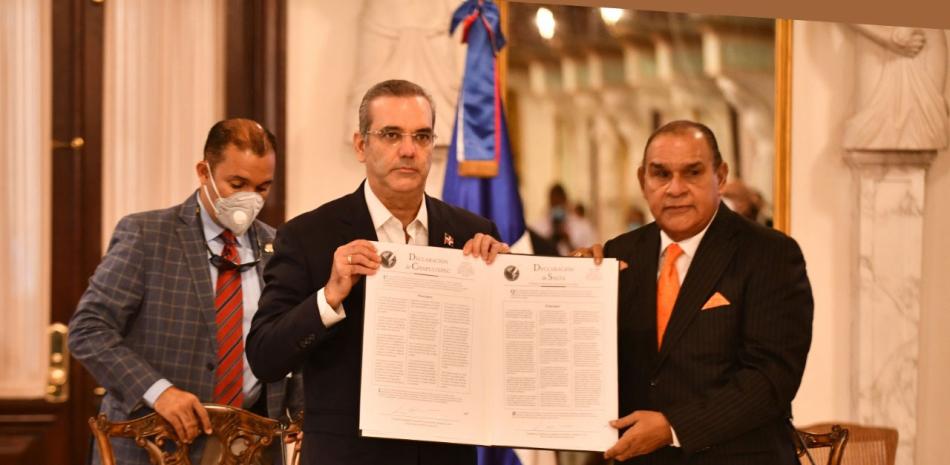 El presidente Luis Abinader (centro) y el director del Listín Diario, Miguel Franjul, muestran las declaraciones de  Chapultepec y de Salta, firmadas por el mandatario en octubre pasado durante un acto en el Palacio Nacional.