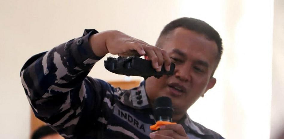 Esta foto del folleto tomada el 24 de abril de 2021 y publicada por las Fuerzas Armadas de Indonesia muestra a un oficial naval mostrando partes del sistema de torpedos encontrado en la operación de búsqueda del submarino KRI Nanggala (402) de la Armada que desapareció el 21 de abril durante un ejercicio de entrenamiento. la costa de Bali, en una conferencia de prensa en Denpasar. FOLLETO / MILITAR INDONESIO / AFP