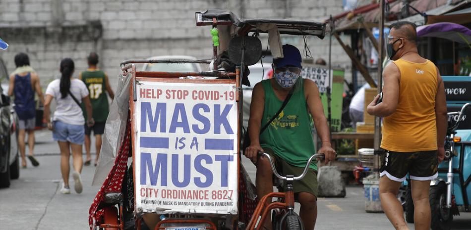 Un hombre maneja un vehículo a pedales con un lema que recuerda a la gente que emplee mascarilla para frenar los contagios de coronavirus, en Manila, Filipinas, el lunes 26 de abril de 2021.

Foto: AP/Aaron Favila