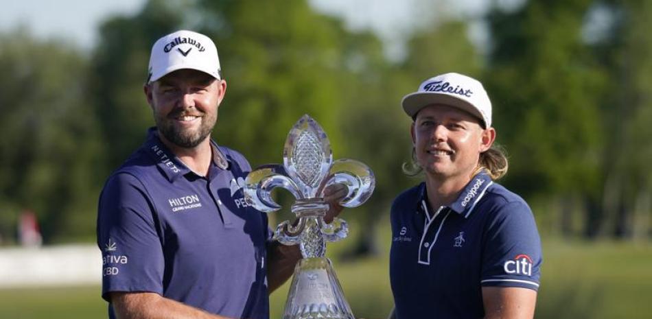 Los australianos Marc Leishman y Cameron Smith sostienen el trofeo después de ganar el PGA Zurich Classic en TPC Louisiana, en Avondale, Luisiana. (AP Foto/Gerald Herbert)