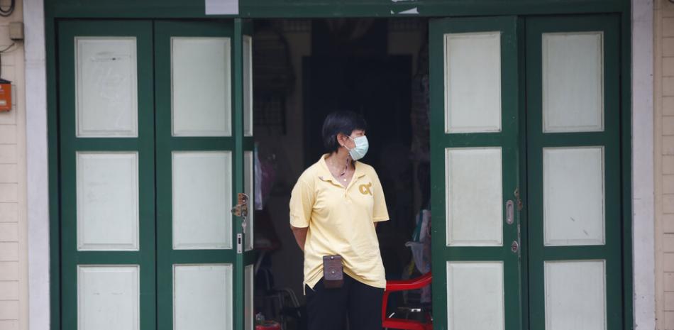 Una tendera con mascarilla para frenar los contagios de coronavirus ante su tienda en la calle Khao San, popular entre tailandeses y turistas en Bangkok, Tailandia, el lunes, 26 de abril de 2021.

Foto: AP/Anuthep Cheysakron