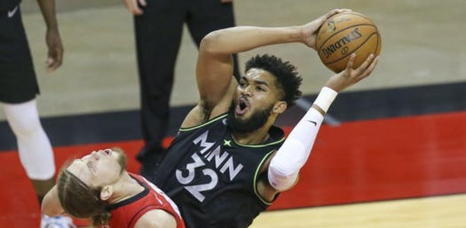 El pívot de los Timberwolves, Karl-Anthony Towns, es bloqueado por el alero de los Rockets, Kelly Olynyk durante el primer cuarto.