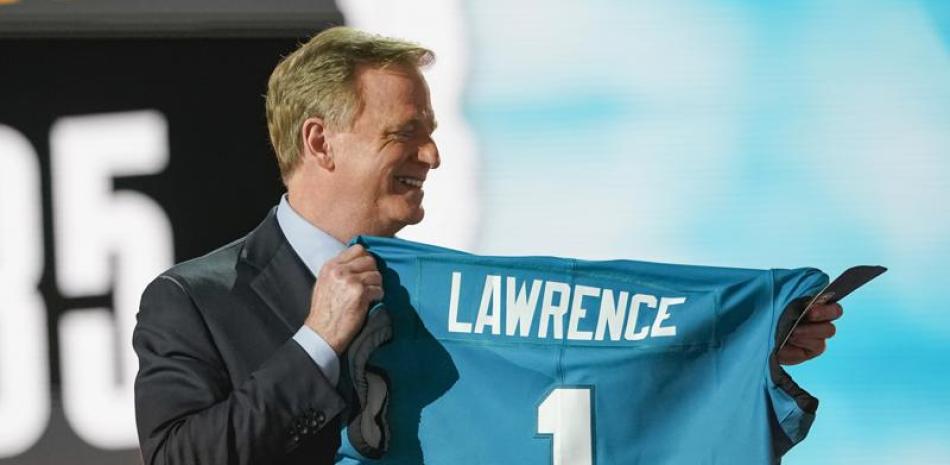 Roger Goodell, comisionado de la NFL, sostiene un jersey con el apellido de Trevor Lawrence, reclutado por los Jaguars de Jacksonville como la primera selección del draft en Cleveland (AP Foto/Tony Dejak)