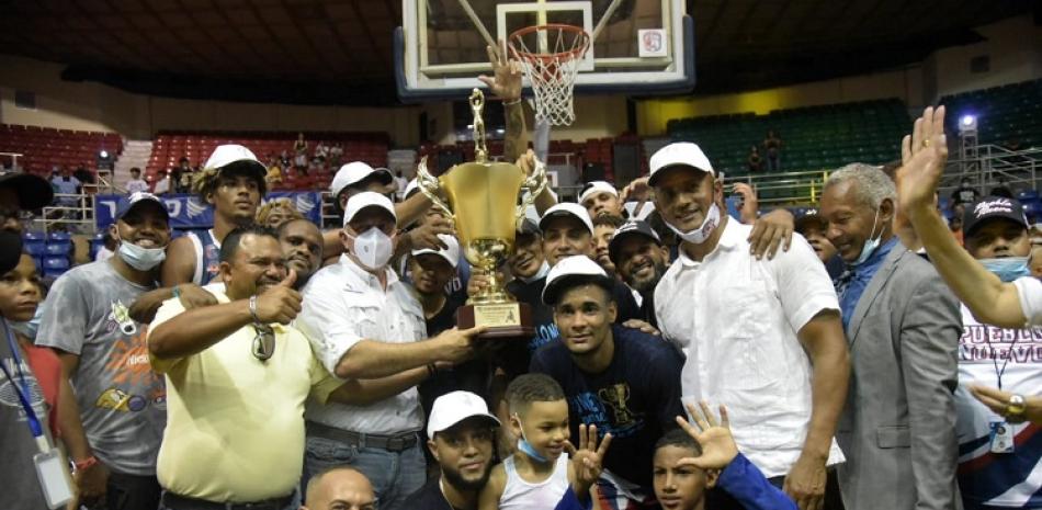 Jugadores, entrenadores, directivos y fanáticos del club Pueblo Nuevo recibe la Copa que acredita al equipo como campeón del torneo de baloncesto superior de Santiago en su edición del 2021.