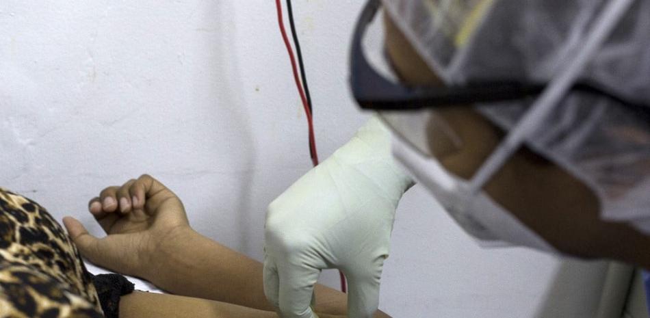 Una enfermera de la organización Médicos Sin Fronteras (MSF) coloca un implante anticonceptivo en el brazo de una mujer en Barcelona, Estado Anzoátegui, Venezuela, el 17 de marzo de 2021. Pedro Rances Mattey / AFP