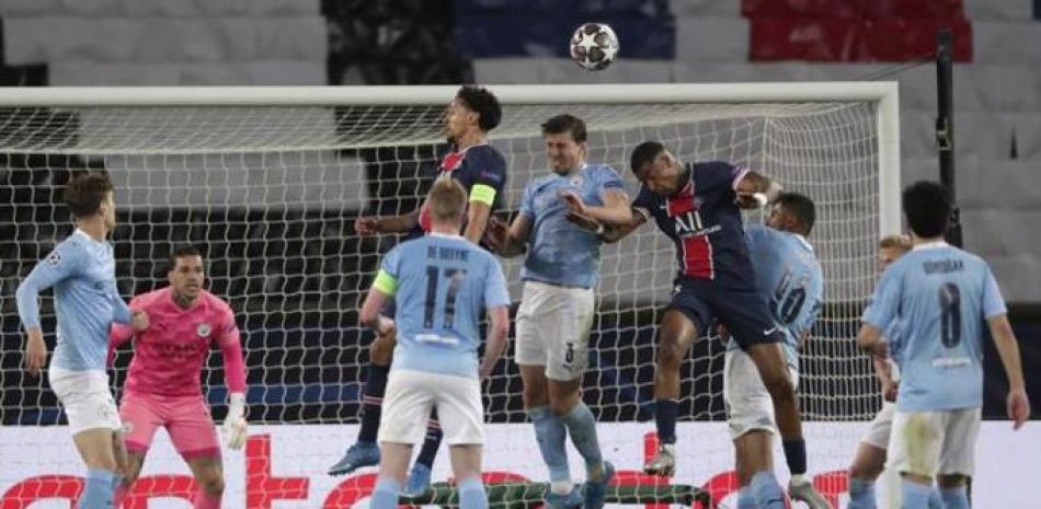 Jugadores del Manchester City y el París Saint Germain luchan por cabecear un balón en acción del partido de ida de la semifinal de la Liga de Campeones.