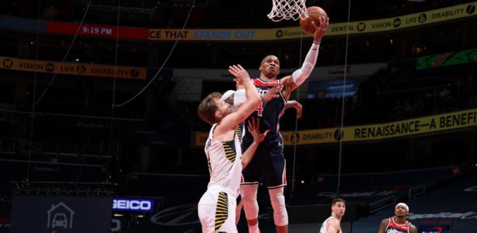 Russell Westbrook, de los Wizards, se eleva en busca de un canasto ante la defensa de Domantas Sabonis, de Indiana, en acción del partido del lunes en la NBA.