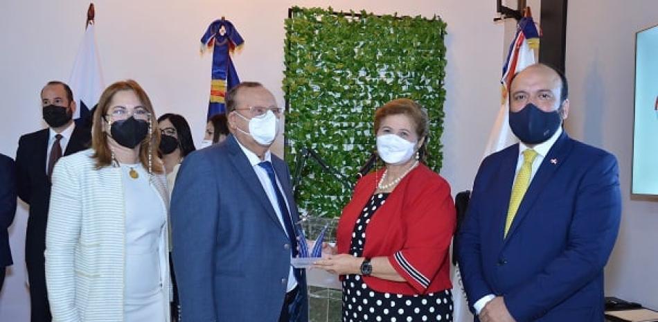 El viceministro de MICM Ramon Perez entrega una placa a Don Osiris Grullon y Marisela Aybar de Grullon. Kathy Ann Grullon Aybar.