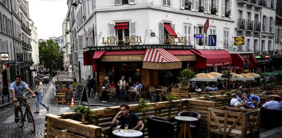 En esta foto de archivo tomada el 23 de julio de 2020, personas toman bebidas en la terraza extendida de un café hecho con paletas de madera en París en respeto al distanciamiento social debido a la pandemia del coronavirus COVID-19. Christophe ARCHAMBAULT / AFP
