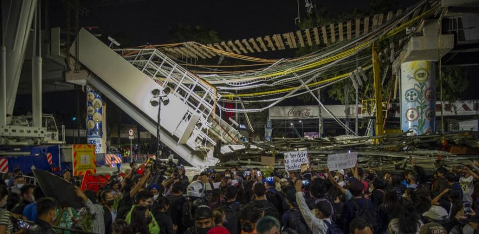 La gente se reúne para protestar en el lugar de un accidente de tren donde una línea elevada del metro colapsó parcialmente, durante un evento en honor a las víctimas, en la Ciudad de México, el 7 de mayo de 2021. El colapso de un paso elevado del metro de la Ciudad de México que dejó a 25 personas La muerte podría haber sido causada por defectos en las vigas de acero o daños en las juntas, dijeron los expertos a la AFP.
CLAUDIO CRUZ / AFP