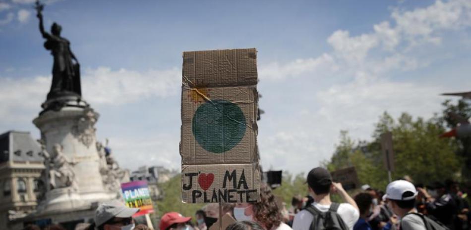 Una joven sostiene un letrero con la frase "Amo a mi planeta" en francés, durante una protesta contra el cambio climático en París, el domingo 9 de mayo de 2021. (AP Foto/Christophe Ena)