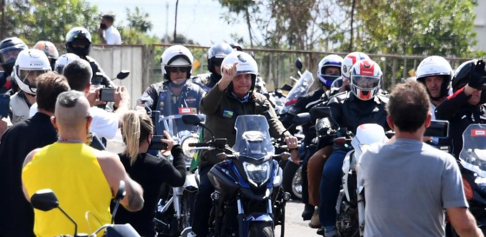 El presidente de Brasil, Jair Bolsonaro, conduce una motocicleta mientras lidera una caravana de más de 1000 ciclistas para celebrar el Día de la Madre en Brasilia el 9 de mayo de 2021. EVARISTO SA / AFP