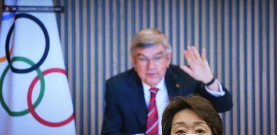 El presidente del COI Thomas Bach, en foto del 28 de abril de este año, en un pantalla saluda a la presidenta del comité organizadora de los Juegos de Tokio Seiko Hashimoto al comienzo de una reunión.