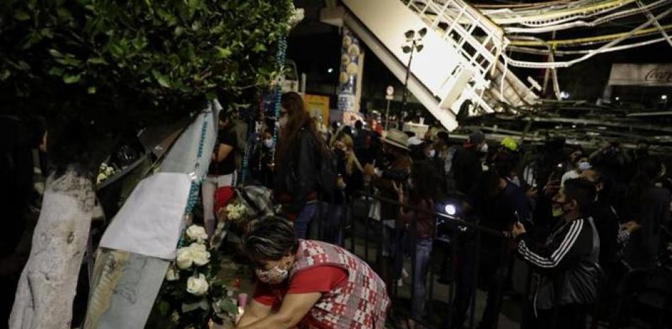 Una mujer coloca flores en un altar improvisado durante una protesta el viernes 7 de mayo de 2021 en demanda de justicia para las personas que fallecieron el lunes debido a un derrumbe en un tramo elevado del metro en la Ciudad de México.

Foto: AP/Eduardo Verdugo