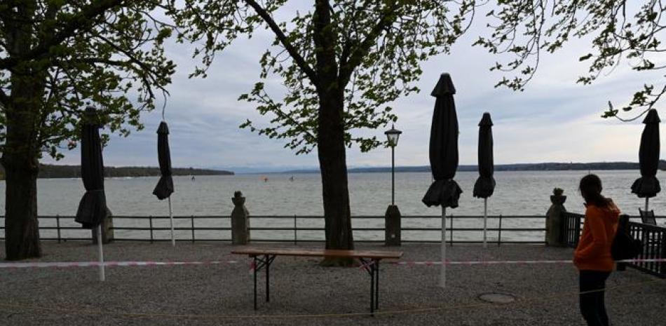 Una mujer se encuentra en una cervecería al aire libre vacía cerca del lago Ammersee en Stegen, en el sur de Alemania, el 4 de mayo de 2021, en medio de la pandemia del nuevo coronavirus Covid-19 en curso. Christof STACHE / AFP