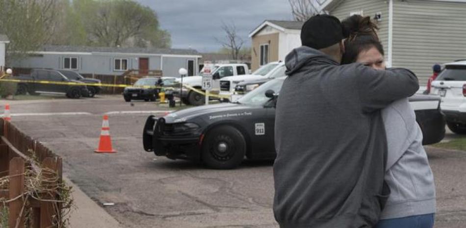 Un hombre y una mujer se abrazan en la calle frente al sitio donde ocurrió un tiroteo el domingo 9 de mayo de 2021, en Colorado Springs, Colorado. (Jerilee Bennett/The Gazette vía AP)