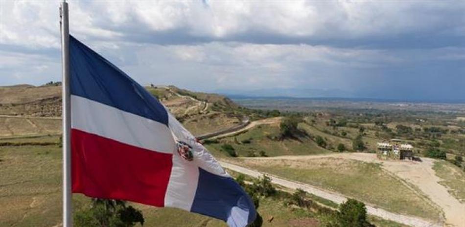 Fotografía aérea tomada con un dron que muestra la bandera de República Dominicana mientras ondea sobre la verja fronteriza entre República Dominicana y Haití, el 8 de mayo de 2021, en Comendador, colinas de Elías Piña (República Dominicana). EFE/ Orlando Barría.