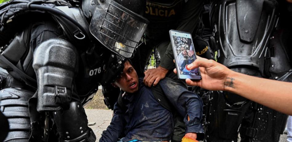 Policías colombianos arrestan a un manifestante durante una protesta contra el gobierno en Cali, Colombia, el 10 de mayo de 2021. Luis ROBAYO / AFP