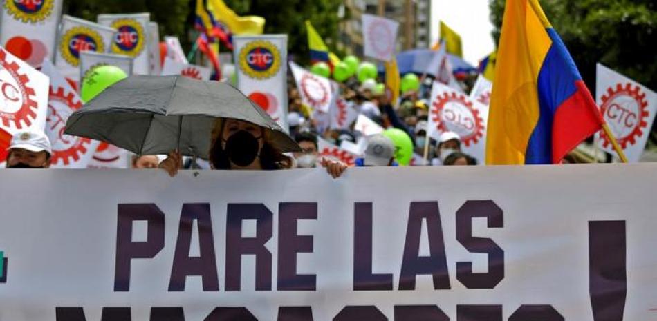 La gente participa en una nueva protesta contra el gobierno del presidente colombiano Iván Duque con una pancarta que dice “Alto a las masacres”, en Bogotá el 12 de mayo de 2021. Raúl ARBOLEDA / AFP
