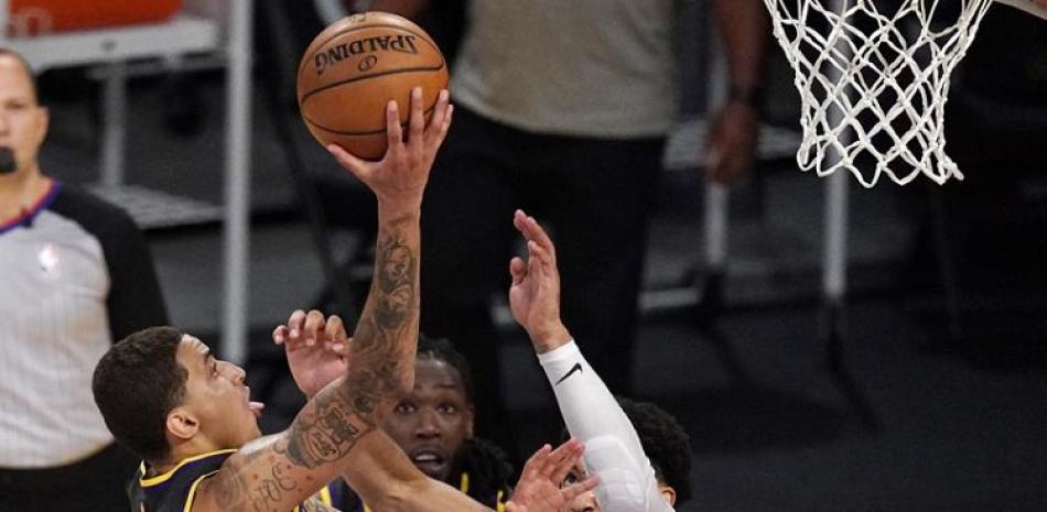 Kyle Kuzma, de los Lakers, hace un intento al canasto sobre la defensa de Kenyon Martin Jr., de los Rockets, en acción del miércoles en la NBA.