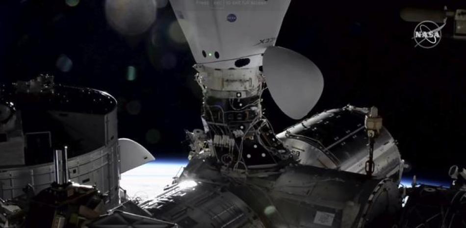En esta imagen tomada de NASA TV, la cápsula de carga Dragon atraca en la Estación Espacial Internacional, el lunes 7 de diciembre de 2020, junto con una cápsula de la tripulación Dragon que transportaba astronautas hace tres semanas.

Foto: NASA vía AP