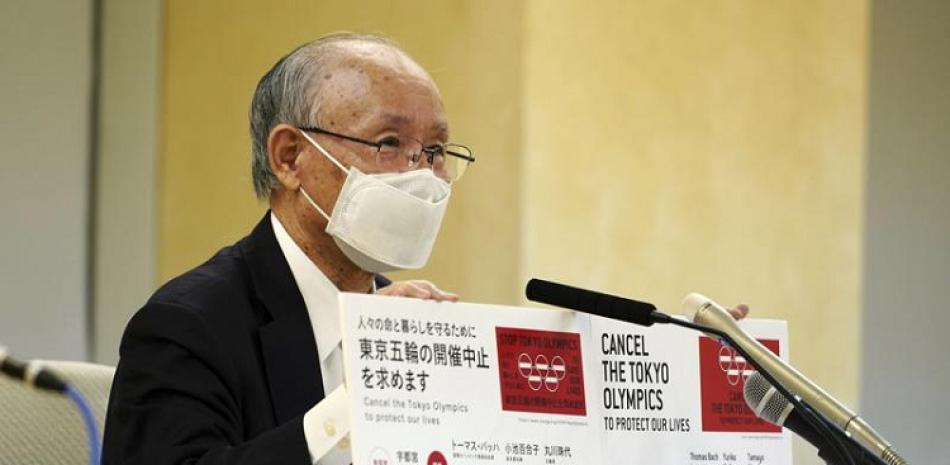 El abogado Kenji Utsunomiya, representante de un grupo anti-Juegos Olímpicos, muestra tableros con la cifra actual de firmas de un petitorio online.