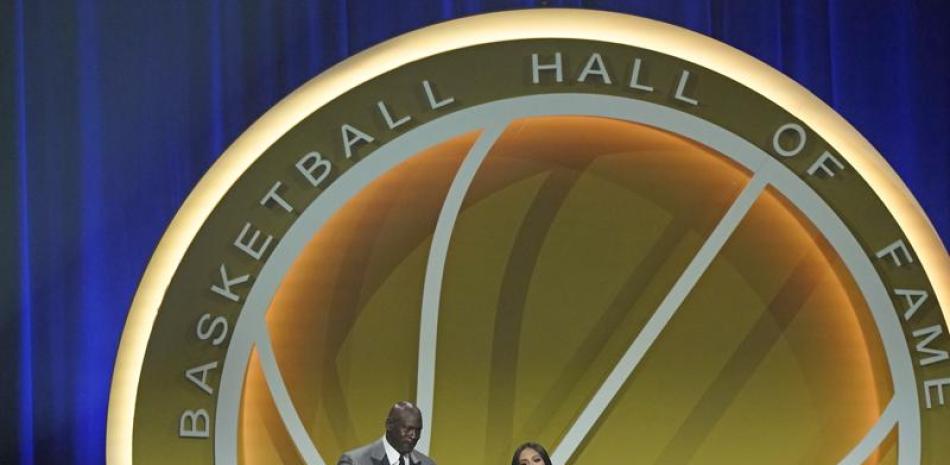 Michael Jordan toma de la mano a Vanessa Bryant, viuda de Kobe Bryant, quien dio el mensaje en nombre de su esposo durante la ceremonia del Salón de la Fama del baloncesto 2200,. (AP Photo/Kathy Willens)