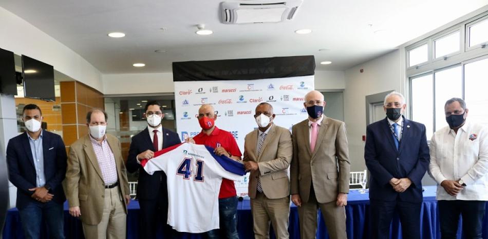 Simón Grullón, ejecutivo de BanReservas, entrega al manager Héctor Borg el uniforme que utilizará el equipo dominicano en el Preolímpico de Béisbol.